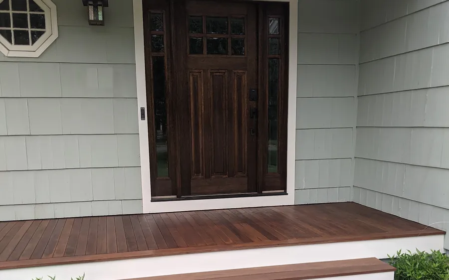 Stained craftsman entry door with sidelights on an ipe front porch of a Monmouth County, NJ home