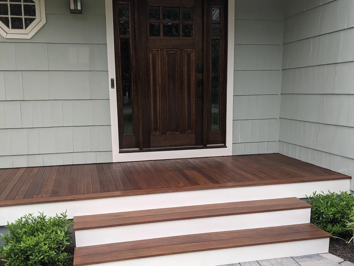 Stained craftsman entry door with sidelights on an ipe front porch of a Monmouth County, NJ home, installed by RSC Contracting LLC