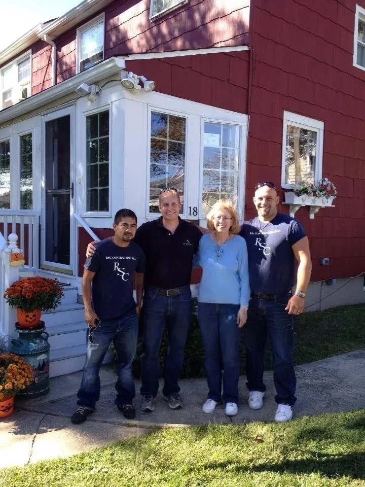 Rob Crotzer, owner of RSC Contracting LLC, with his crew and a longtime client outside her Monmouth County home